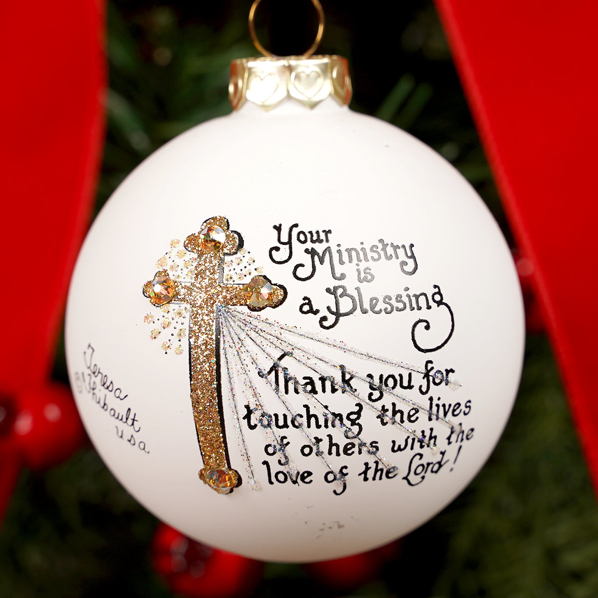 Decorative Christmas ornament with a cross and text on a white background.