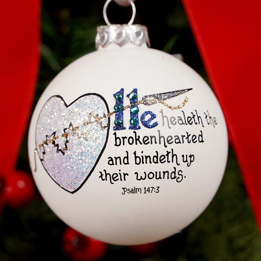 Decorative Christmas ornament with Broken heart design and Psalm 147:3  on a red background