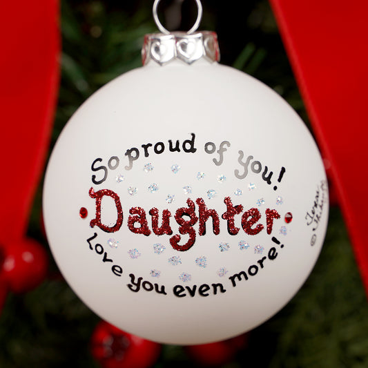 Christmas ornament with text 'So proud of you! Daughter, love you even more!' on a tree.