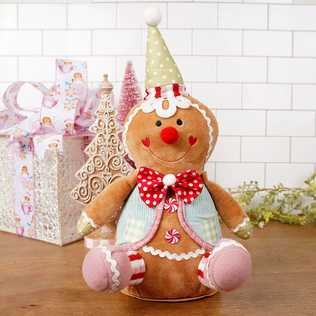 Gingerbread man plush toy with decorative elements on a wooden surface.