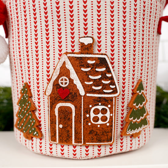 Decorative item with a gingerbread house and trees on a knitted background