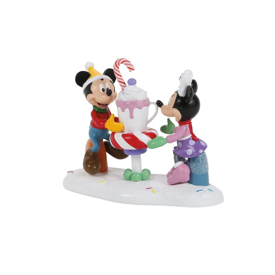 Figurine of Mickey and Minnie with a candy cane and a mug of cocoa on a white background