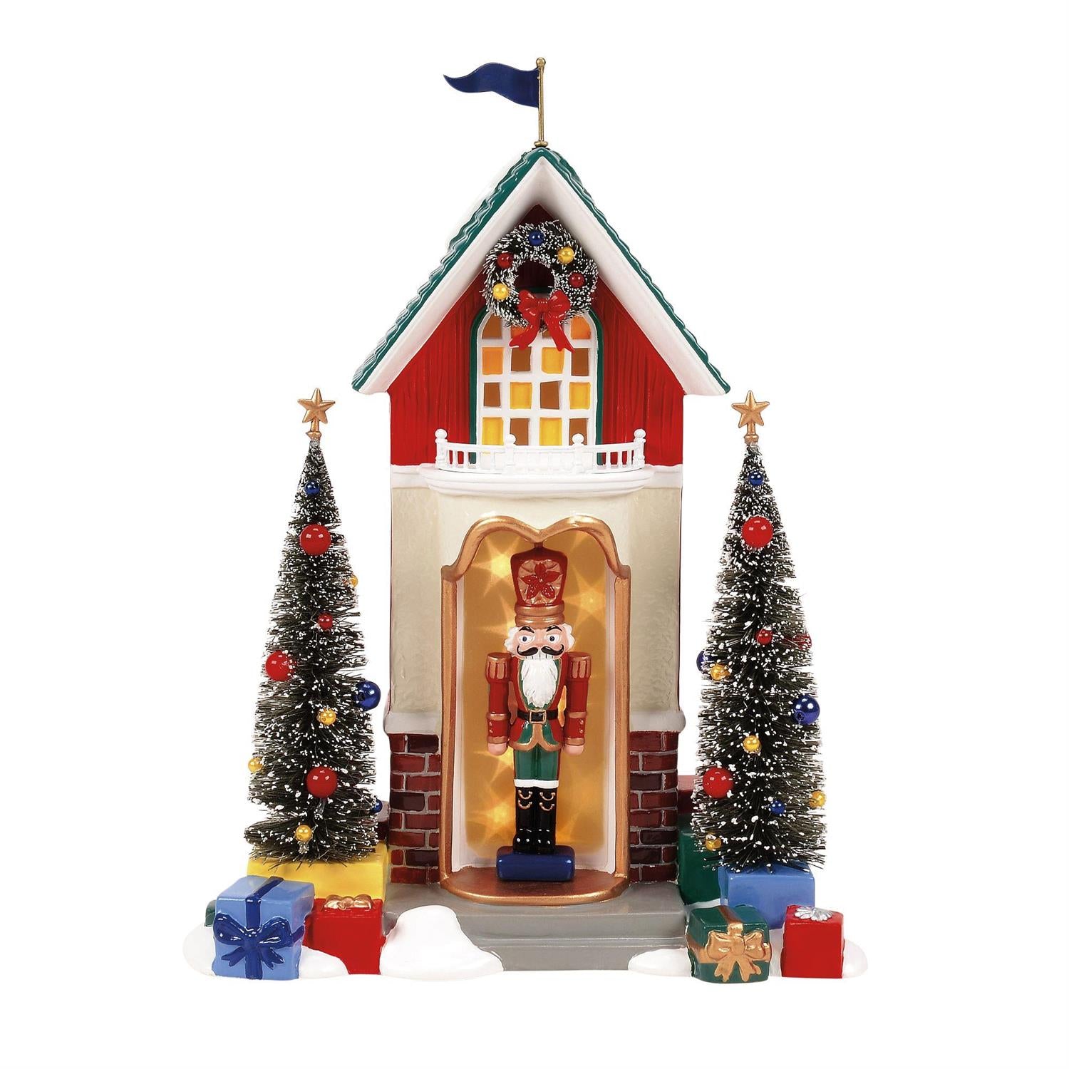 Decorative Christmas scene with a house, trees, and a nutcracker figure on a white background