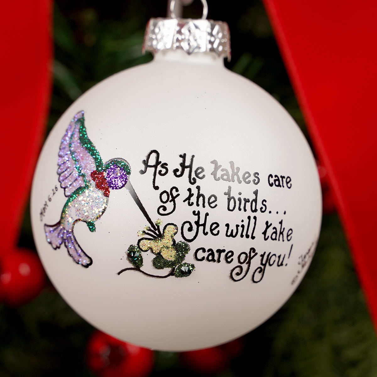 Decorative Christmas ornament with a hummingbird and text on a white background.