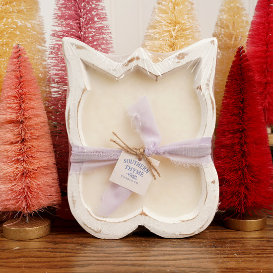 Butterfly-shaped bath bomb in a decorative box with bottlebrush trees in the background