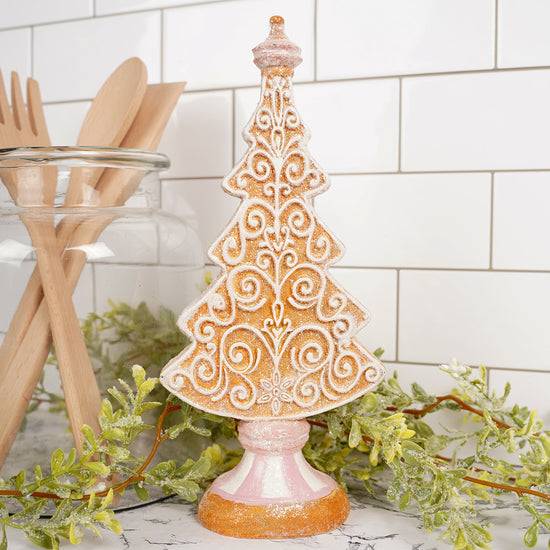 Decorative gingerbread tree on a stand with kitchen utensils and greenery in the background Christmas Place