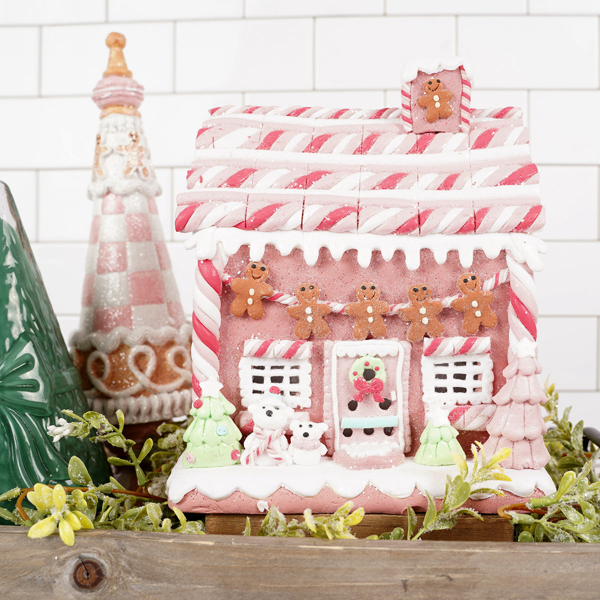 Decorative gingerbread house with candy decorations on a white tiled wall background Christmas Place