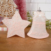Decorative star and bell ornament on a wooden surface with a blurred background