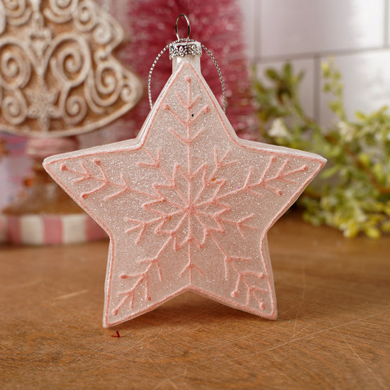 Star-shaped decorative ornament with snowflake pattern on a wooden surface