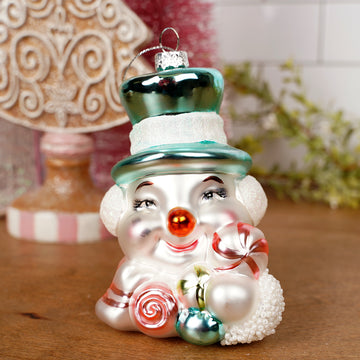 Decorative Christmas ornament shaped like a clown with candy, on a wooden surface.